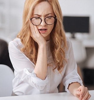 Woman holding jaw in pain