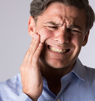 Man holding jaw in pain