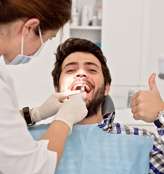man in dentist chair thumb up