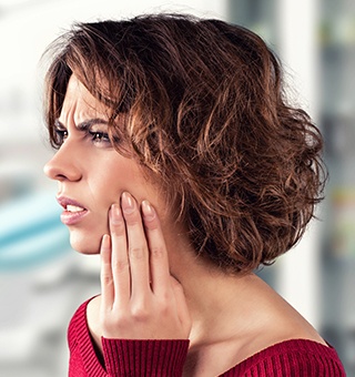 Woman in pain holding cheek