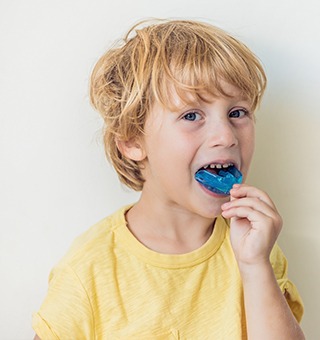 Young boy placing mouthguard