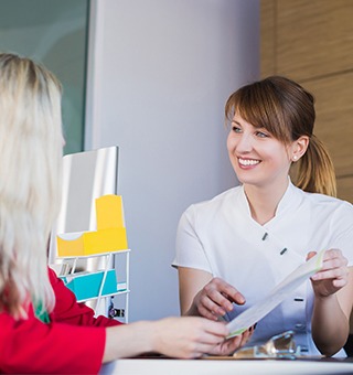 Team member showing patient insurance forms