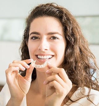 Woman placing Invisalign tray