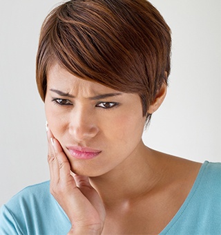 Woman holding cheek in pain