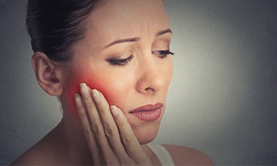 Woman holding jaw in pain